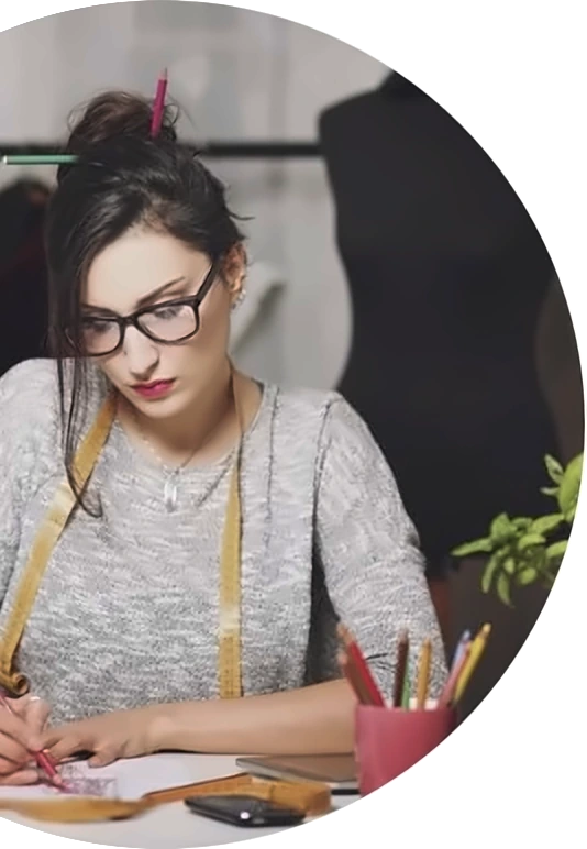 Karren, a fashion boutique owner, sketching at her workbench